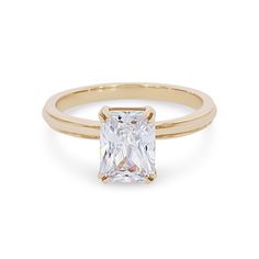 a yellow gold ring with a princess cut diamond