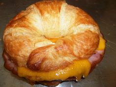 a croissant sandwich sitting on top of a metal counter