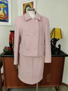 This suit was made in the 1970s in Italy and is well styled in the European tradition in a pale muted pink wool boucle fabric. The jacket features a small collar, a double breasted closure with large gold and pearly buttons, has faux pockets at the hips and a cropped length. The straight skirt also is fully lined in a peachy pink nylon fabric, and is a mini above knees length . The condition is good but would improve with a drycleaning to refresh it. The measurements are Skirt Waist 78cm Hips 10 Fitted Pink Skirt Suit For Winter, Pink Formal Skirt Suit For Fall, Pink Skirt Suit For Formal Fall Occasions, Vintage Pink Blazer For Work, Above Knee Skirt, Knee Skirt, Muted Pink, Knee Skirts, Better Style