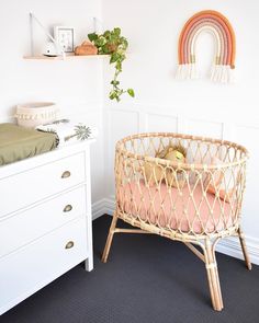 a baby's crib in the corner of a room with white walls and black carpet