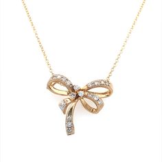 This estate 14K Yellow Gold diamond bow pendant is a timeless piece, blending classic charm with sparkling elegance. It features 0.30 ctw of round brilliant diamonds that radiate with SI1-2 clarity and H-I color grades, ensuring a dazzling display of light and brilliance. The bow design adds a touch of whimsical sophistication, making it an exquisite focal point. Accompanying the pendant is a new 14K Yellow Gold chain, measuring 20 inches in length, providing the perfect drop to complement any n Luxury Diamond Bow Jewelry, Elegant Diamond Jewelry With Bow Detail, Bow Pendant, Diamond Bows, Yellow Gold Chain, Bow Design, Brilliant Diamond, Estate Jewelry, Round Brilliant