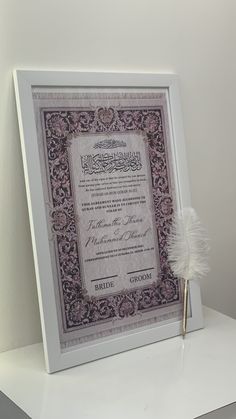 a framed certificate with a feather on it