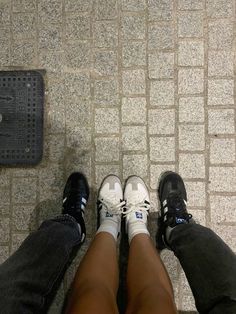 two people standing next to each other with their feet on the ground and one person wearing sneakers