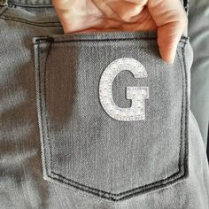 someone is holding their pocket with the letter g on it's side and there are two fingers in the pocket