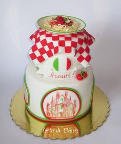 a three tiered cake with red and white checkers on the top is shown