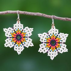 the earrings are made from seed beads and beaded with colorful colors, on a branch