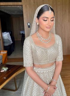 a woman in a white wedding dress standing next to a table