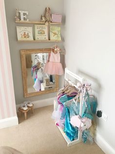 a room with a mirror, clothes rack and other items on the floor in front of it