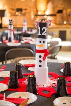 there is a snowman made out of paper plates on the table with candy canes