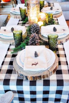 the table is set with pine cones, candles and plaid napkins for an elegant look