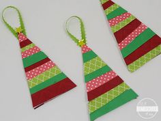 three christmas trees made out of paper on a white table with green and red ribbons