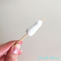 a person is holding a toothpick with something white on it's tip