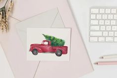 a red truck with a christmas tree on the back is sitting next to a keyboard