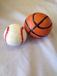 two orange and white balls sitting next to each other on a tablecloth covered surface