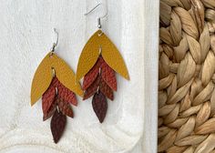 These falling leaves leather earrings are so beautiful! Featuring mustard yellow, warm brown, burnt orange and chocolate brown leather. Handmade with a high quality leather that is great for everyday wear.  These earrings are lightweight and easy to wear!  The leaf measures about 2.8 inches in length by 1.5 inch at the widest. Featuring surgical stainless steel nickel free fish hook ear wire. Join our facebook group Glitter and Leather Co VIP for sneak peaks, discounts and giveaways! Follow us on Instagram:  Instagram.com/glitterandleatherco Glitter and Leather Co is handmade jewelry line by  Anita Recksiedler.  Featuring easy to wear lightweight earrings for both teenagers and adults.  Made in Winnipeg, Manitoba Canada.   Are you local?  Free Pickup available use code PICKUPWPG  for no sh Handmade Leather Jewelry, Fall Leather, Black And White Earrings, Autumn Leaf, Falling Leaves, Flower Plates, Orange Leather, Warm Brown, Enamel Charms