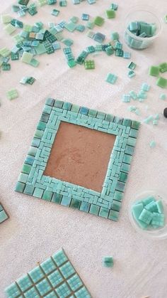 several pieces of blue and green mosaic tile laying on the ground next to each other