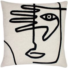 a black and white pillow with a face drawn on the front, in an abstract manner