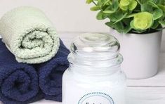 a white jar sitting on top of a blue towel next to a potted plant