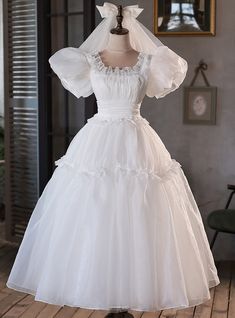 a white wedding dress on display in a room