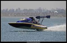 a blue and yellow speed boat speeding across the water