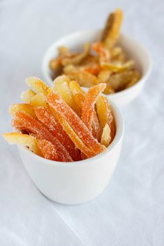 two small white bowls filled with food on top of a table