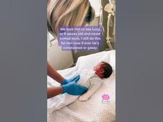 a woman in blue gloves is laying on a hospital bed with a baby wrapped in a blanket