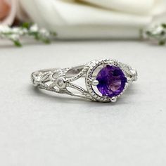 This beautiful ring is made from genuine 925 sterling silver with rhodium plating. Ring details- -The Main stone is a round cut 6mm Natural Amethyst -Side stones are Round Clear 1mm simulated diamonds -Ring is casted in solid 925 sterling silver with rhodium plating (yellow gold and rose gold plated also available, please check the drop down menu for more options) -The Total face height of the ring measures 10mms and the band width measures 2mms -Each ring is handmade and made to order, so pleas Classic Amethyst Birthstone Ring In White Gold, Classic Amethyst Promise Ring With Center Stone, Classic Amethyst Crystal Ring For Anniversary, Elegant White Gold Amethyst Promise Ring, Heirloom Amethyst Diamond Promise Ring, White Gold Amethyst Crystal Ring With Accent Stones, Elegant Silver Amethyst Diamond Ring, Promise Amethyst Ring In White Gold With Center Stone, White Gold Amethyst Rings With Accent Stones