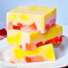 three pieces of fruity candy on a white plate with red, yellow and green squares