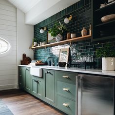 a kitchen with green cabinets and wooden floors