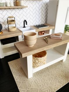 a miniature kitchen with white cabinets and wooden counter tops, including a bowl on the table