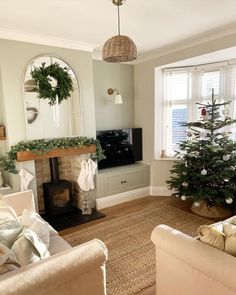 a living room filled with furniture and a christmas tree in front of a fire place