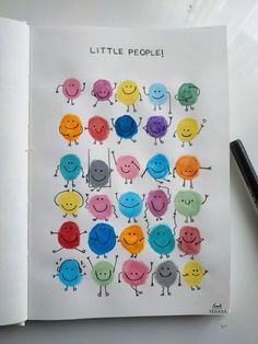 an open book with little people drawn on it next to a pen and pencils