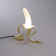 a banana shaped lamp with a cord attached to it's side and the light turned on