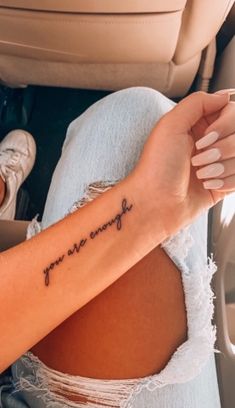 a woman's arm with the words you are enough written in cursive font