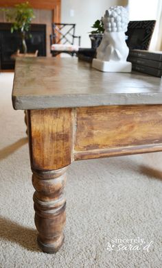 a wooden table sitting on top of a carpeted floor next to a white vase