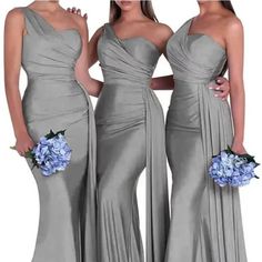 three bridesmaids in grey dresses with blue flowers on their bouquets and one is wearing