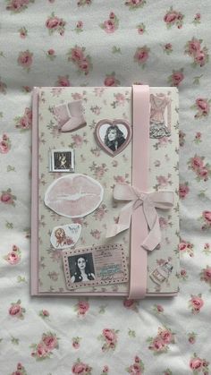 an open book with pink ribbon and pictures on the cover, sitting on a bed