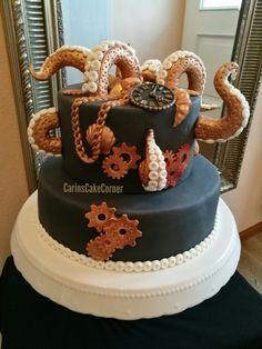 a three tiered cake decorated with gears and chains