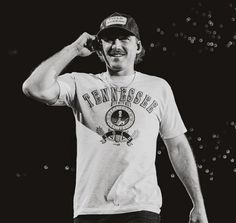 a black and white photo of a man wearing a tennessee t - shirt with the word tennessee on it