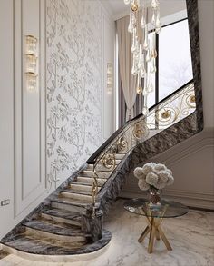 an elegant staircase with chandelier and glass table