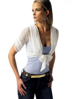 a woman with her hands on her hips wearing jeans and a white top is posing for the camera