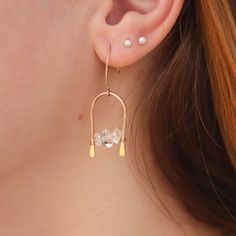 These lovely herkimer diamond arch earrings catch the light as the arches dangle. The herkimers float across the bottom of the arch are bright and luminous - they add a touch of elegance to any kind of look, day or night. They're the perfect pop of modern geometry,  like a little crystal gateway- these Herkimers are wrapped tightly in between the pillars of the archway, and hammered ends keep the wrapped stones stable and secure. These Herkimer stones are luminous and clear, giving a nice glimmer when reflecting light.  Made from quality, eco-friendly 14K gold filled, rose gold filled, or sterling silver, which won't flake or wear off over time. The center stones are approximately 8mm tall. More Herkimer jewelry: https://www.etsy.com/shop/LotusStone?ref=seller-platform-mcnav&search_query=h Modern Drop Diamond Earrings As A Gift, Modern Rose Gold Dangle Earrings, Modern Dangle Crystal Earrings As Gift, Modern Crystal Drop Earrings Gift, Modern Crystal Drop Earrings For Gifts, Modern Drop Crystal Earrings For Gift, Rose Gold Pierced Drop Crystal Earrings, Modern Dangle Crystal Earrings With Ear Wire, Modern Crystal Drop Earrings Pierced