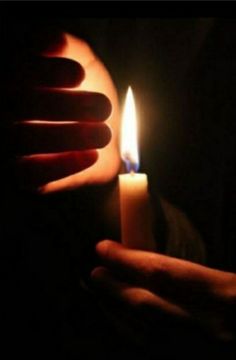 a person holding a lit candle in their hand