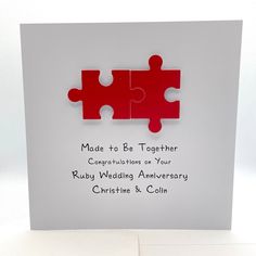 a red puzzle piece is on top of a white card with the words made to be together congratulations on your ruby wedding anniversary