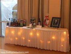 a table with candles and pictures on it in front of a window at an event