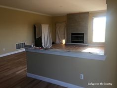 an empty living room with wood floors and a fireplace