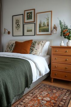 a bedroom with a bed, dresser and pictures on the wall