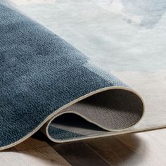 a blue rug on the floor with white and gray carpeting in front of it