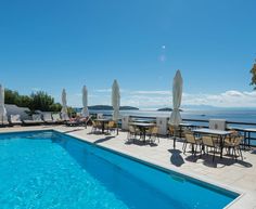 an outdoor swimming pool with chairs and umbrellas