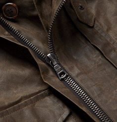 a close up view of the zippers on a brown leather jacket that is open